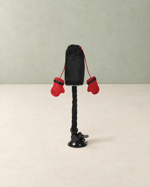 Cat punching bag toy with two red boxing gloves on a bendy stem and suction cup base, on a cream floor