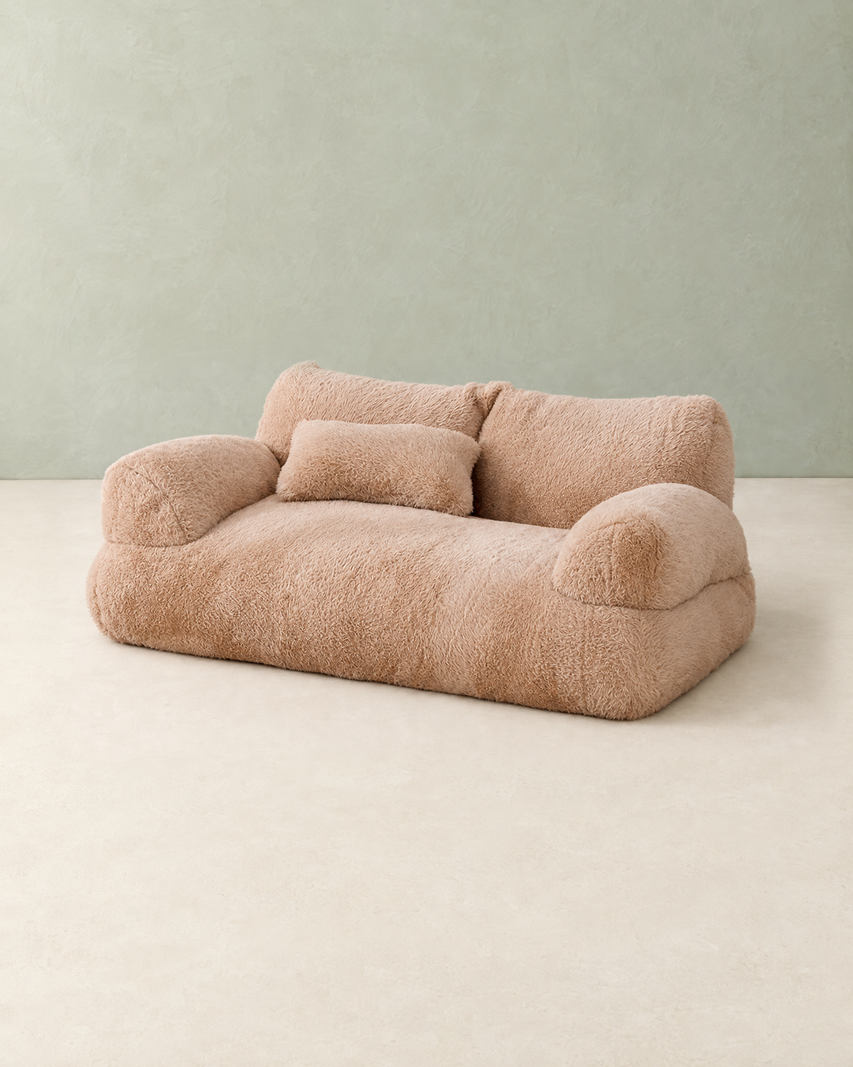 Camel plush dog sofa bed with two back cushions, two rounded armrests and a small pillow, on a cream floor against a pale sage wall