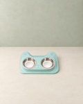 Mint double bowl set with a cat-shaped tray and two stainless steel bowls on a cream floor against a pale sage wall