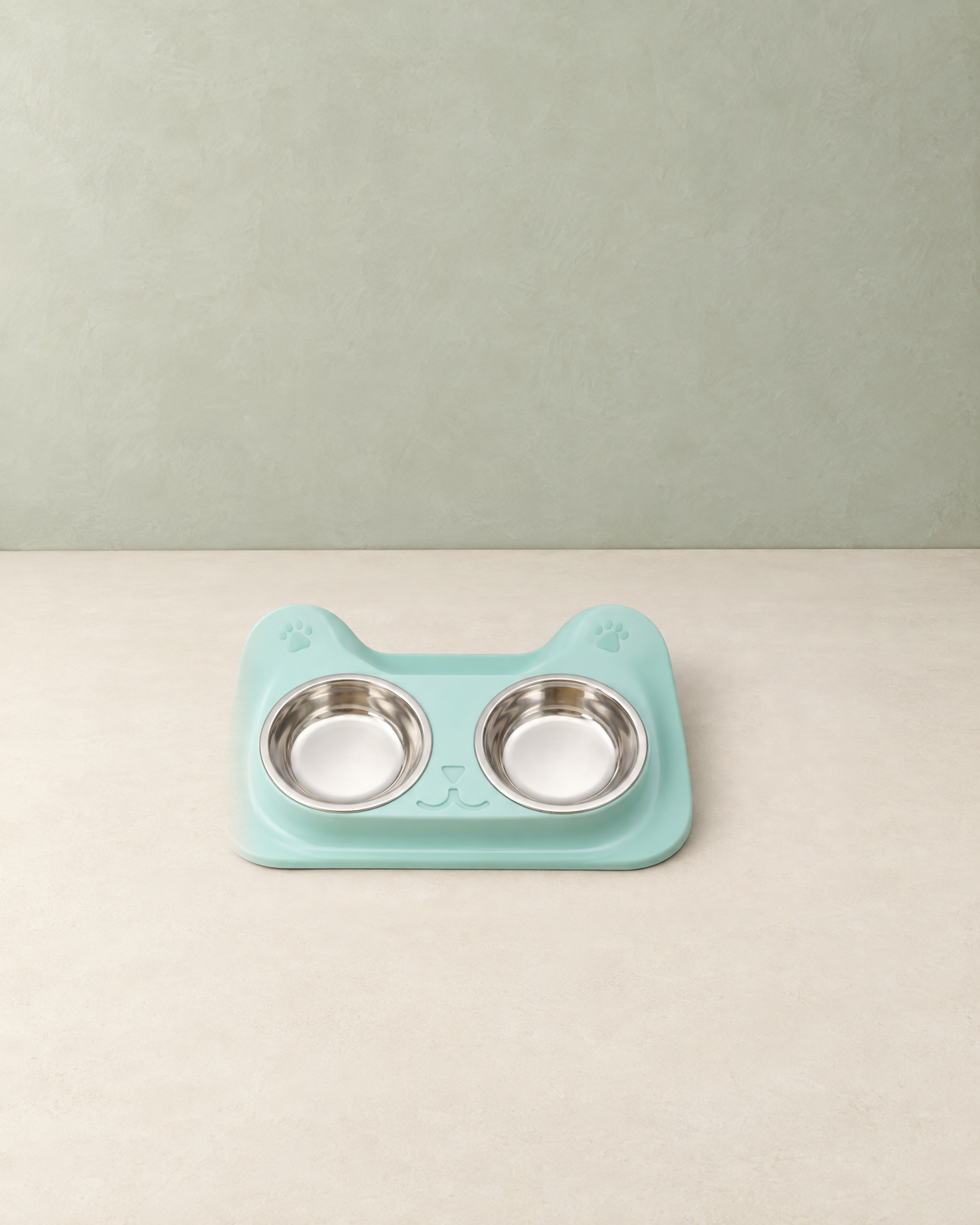 Mint double bowl set with a cat-shaped tray and two stainless steel bowls on a cream floor against a pale sage wall
