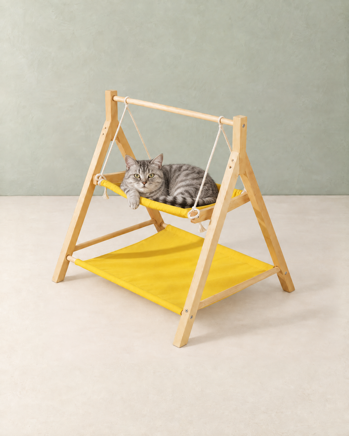 A silver tabby cat lying in the yellow swing hammock of the wooden cat swing bed
