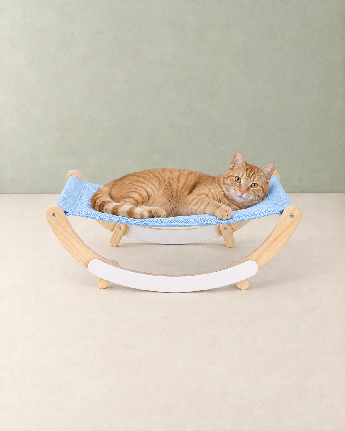 A ginger tabby cat lying in the light blue sling of the wooden rocking cat hammock