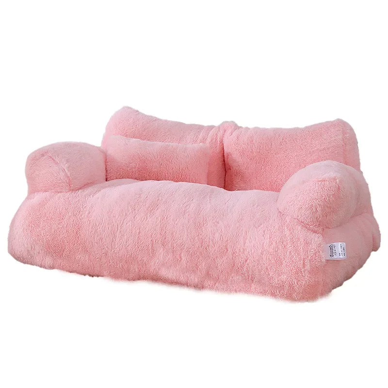 Pink plush dog sofa bed with two armrests and a small pillow