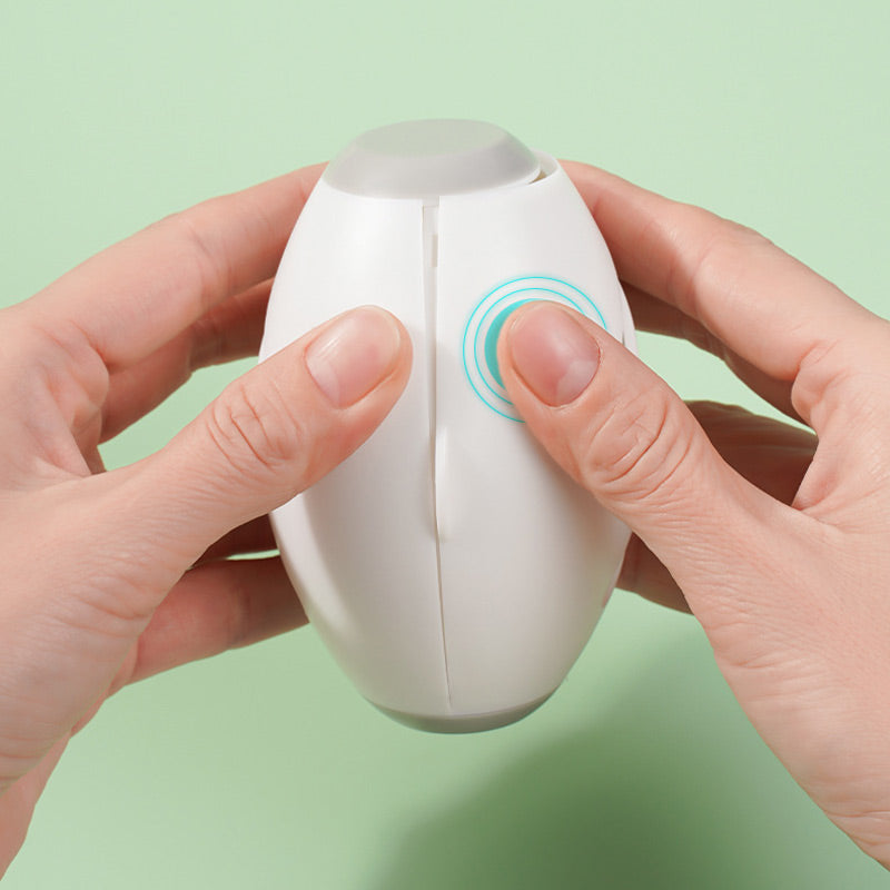 Two hands pressing the button to open a white pet hair roller