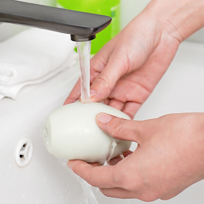 Rinsing the white sticky roller clean under a running tap