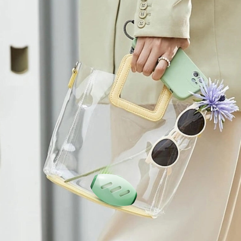 The green roller carried in a clear handbag with sunglasses