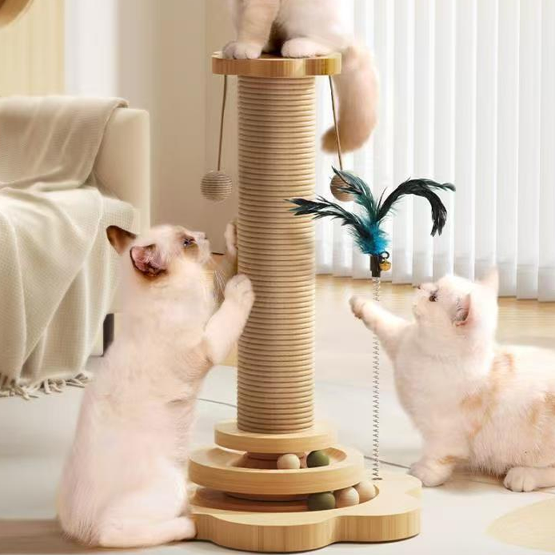 Two white kittens playing at the sisal scratching post, one batting the feather wand