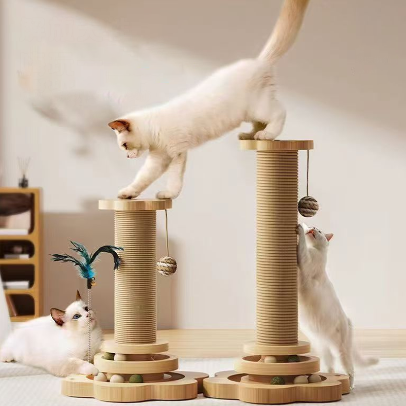 Three white cats climbing and playing on two sisal scratching posts with ball track bases