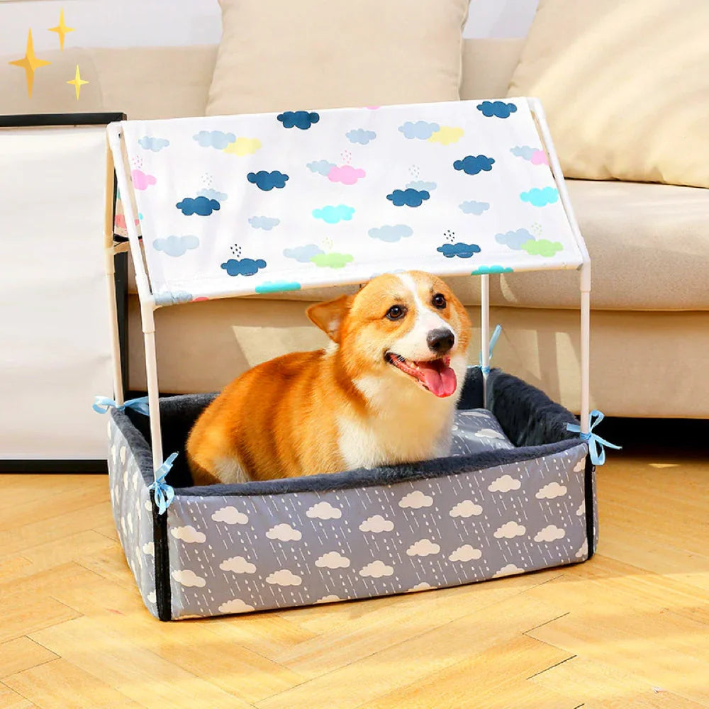 Dog bed with a cloud-print canopy roof and navy fleece lining, a corgi lying inside
